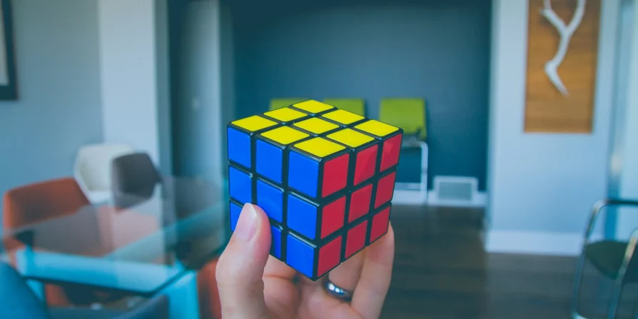 Una mano che tiene un cubo di Rubik parzialmente risolto, simboleggiando la complessità e la strategia nella gestione aziendale